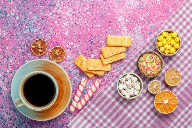饮料在粉红色的桌子上可以看到一杯茶 里面放着饼干和糖果顶部早餐杯子