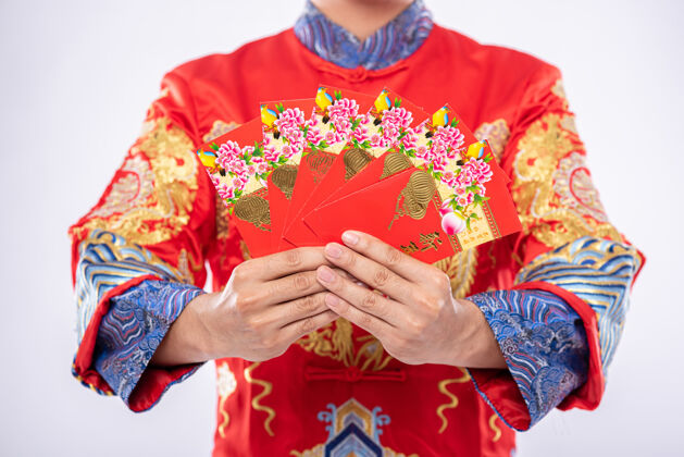 男人穿旗袍西服的男人送给家人一件礼物 让他们在中国新年里成为幸运儿微笑中国文化成熟