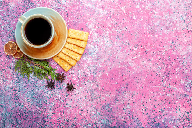 茶托在粉红色的桌子上放一杯茶和饼干饮料茶咖啡