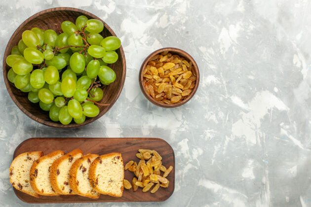 午餐在浅白色的桌子上俯瞰新鲜的绿色葡萄和葡萄干以及蛋糕片饮食醇香营养