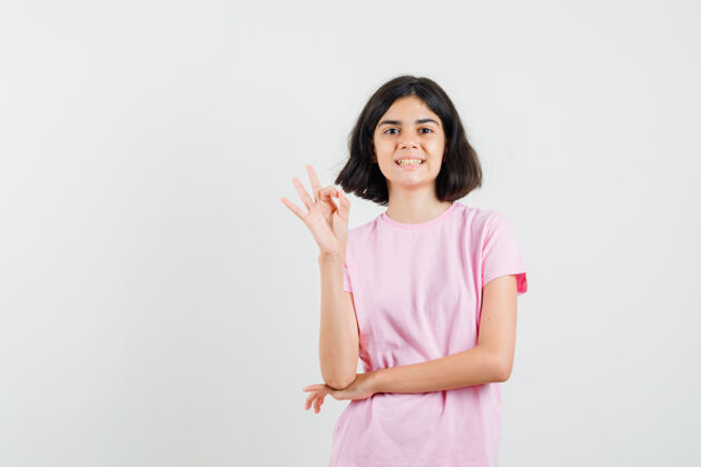 漂亮穿着粉色t恤的小女孩做了一个很好的手势 看起来很开心 正面照青少年女性休闲