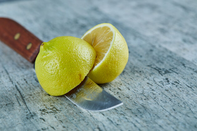 刀多汁的半切黄色柠檬在大理石表面与刀提神特写半