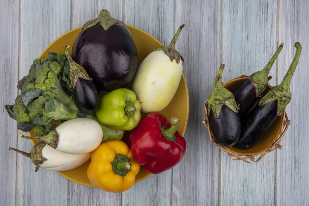 茄子顶视图的蔬菜 如胡椒花椰菜和茄子在盘子和茄子在篮子在木制背景上营养胡椒食物