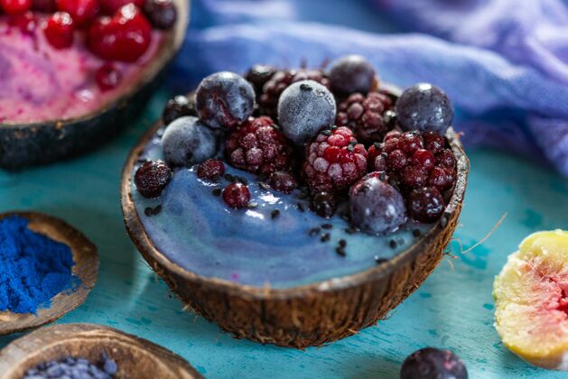 健康特写镜头的水果奶昔顶部冷冻覆盆子和蓝莓在椰子盘有机营养多汁