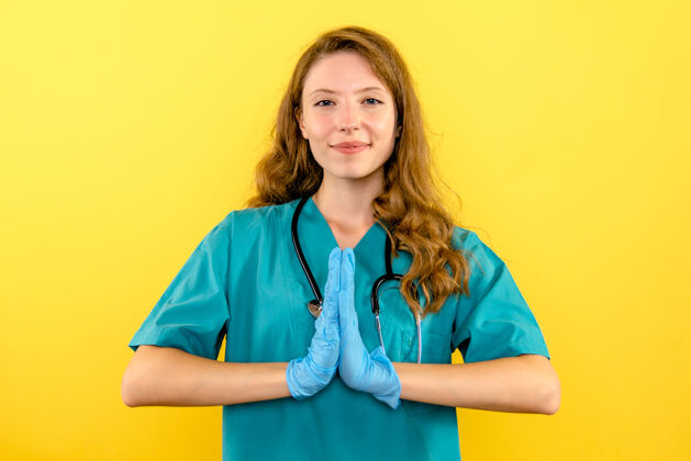 前面黄色空间上戴手套的女医生的前视图健康视图人