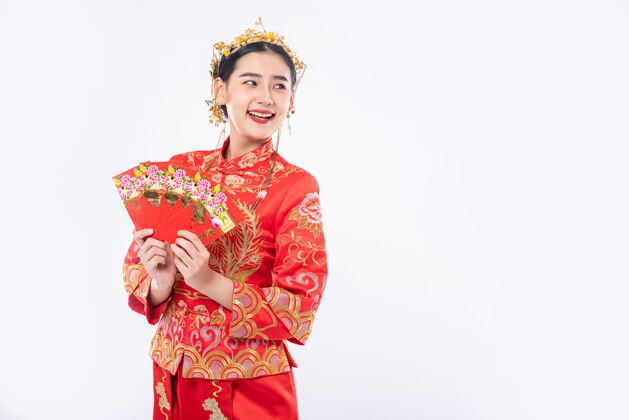 旗袍女人穿着旗袍套装微笑着从家人那里得到新年礼物中国新年女孩成人