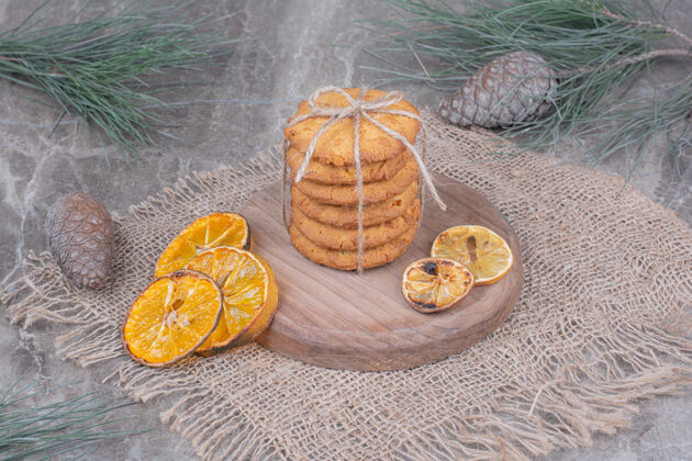 面包房木盘上放着燕麦片饼干 周围放着干橙子片极简小吃糕点