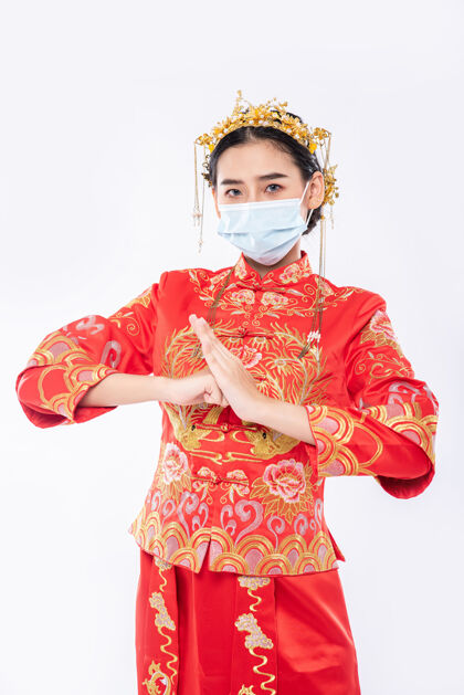 中国民族女士穿旗袍套装 戴口罩 欢迎客户在春节购物手势中国新年中国文化