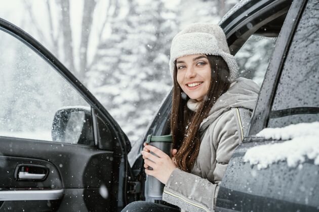 女人笑脸女人在旅途中喝一杯热饮 享受雪景自然户外旅行