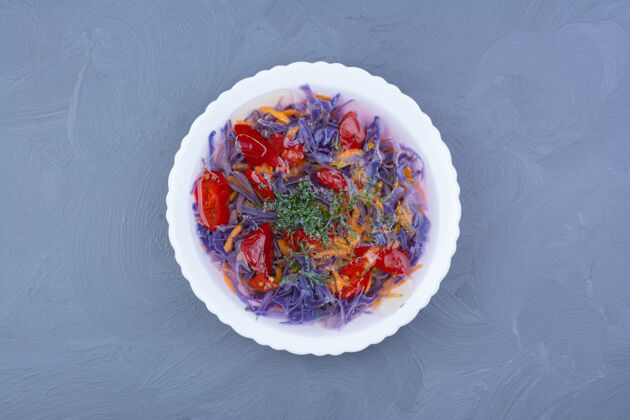 盘子紫色卷心菜和红辣椒酱放在一个白色的碗里香料蔬菜传统