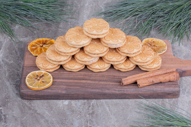 面粉用肉桂棒和干柠檬片放在木板上的饼干圣诞节极简饼干