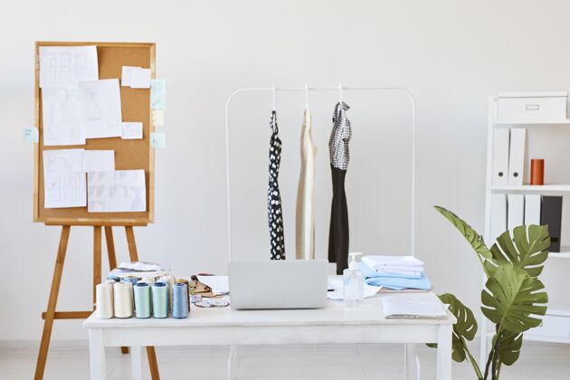 线时尚工作室的正面视图 带有创意板和带有服装线的桌子裁缝Costumiable服装