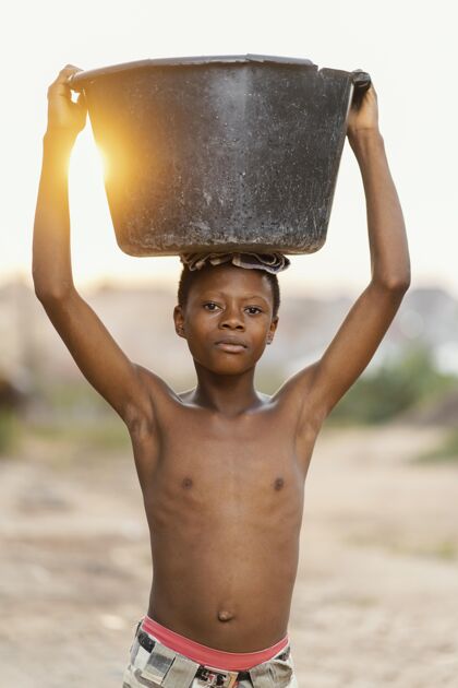非洲人头上戴着脸盆的小男孩脸盆肖像男孩