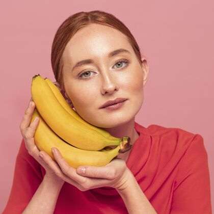 饮食红头发女人在香蕉旁边摆姿势美丽食物美味
