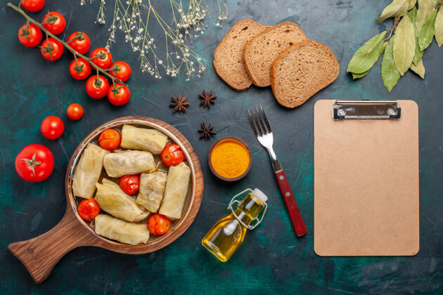 卷俯瞰美味的肉食卷心菜内卷油面包和新鲜西红柿在深蓝色桌上肉食晚餐蔬菜菜烹饪新鲜烹饪盘子