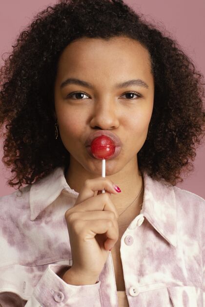 非裔美国人带棒棒糖的笑脸女人的前视图年轻棒棒糖肖像