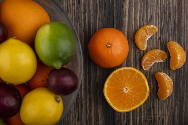 食物顶视图混合水果柠檬酸橙李子桃子和桔子在一个木制的背景花瓶橙色柠檬景观