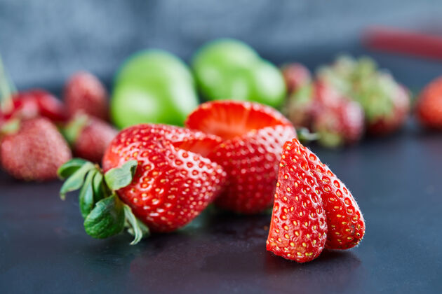 甜新鲜的红色草莓在黑暗的表面多汁叶美味