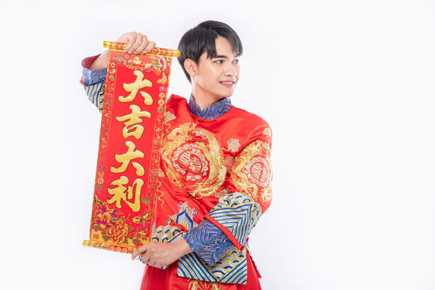 成人穿旗袍西服的男人在中国新年给家人送上中国贺卡祝好运中国民族团结男孩