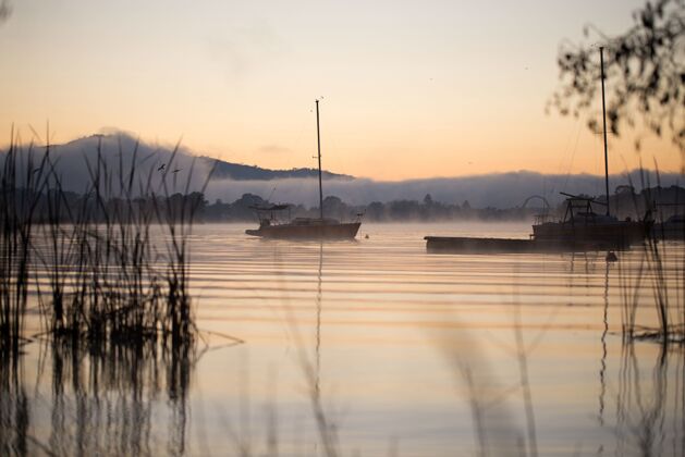 河流迷人的日落倒映在山上的水上的美丽画面早晨船湖泊