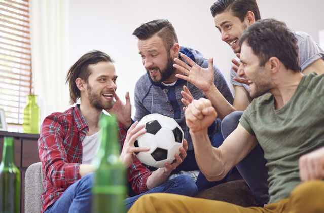 沙发四个最好的朋友在谈论足球比赛得分饮酒足球