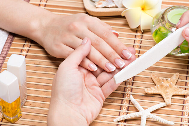 沙龙在美甲沙龙接受美容师美甲的女人美容治疗概念手指女人指甲