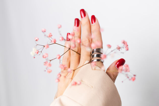 花瓣柔美温柔的照片 女人手上戴着大戒指 红色的指甲 手上拿着可爱的粉色干花浪漫博客美丽