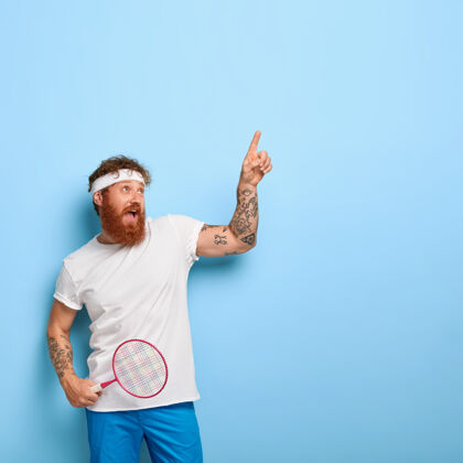 显示穿着运动装的留着胡子的潮人 拿着网球拍纹身情绪羽毛球