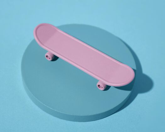 设备蓝色背景上的高角度粉色滑板运动简约爱好