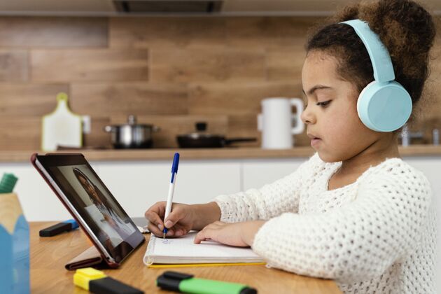 教育侧视图的小女孩在网上学校与平板电脑课程小平板电脑