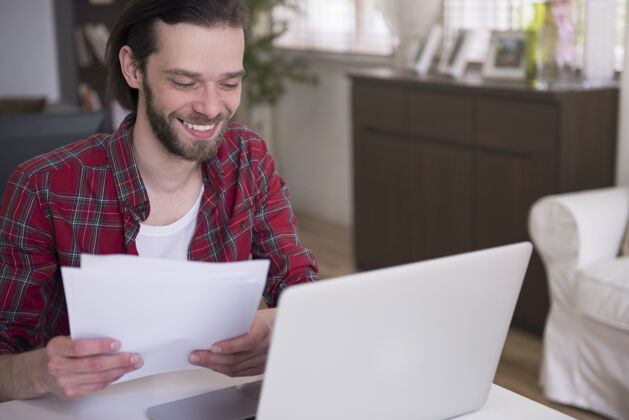 连接在家里用笔记本电脑工作的年轻人看微笑在家工作