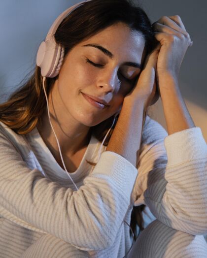 休息时间女人在家睡觉时用耳机听音乐房子逗留女人