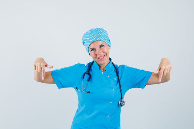 指点女医生穿着蓝色制服指着下面 看上去很高兴正视图诊所实验室成人