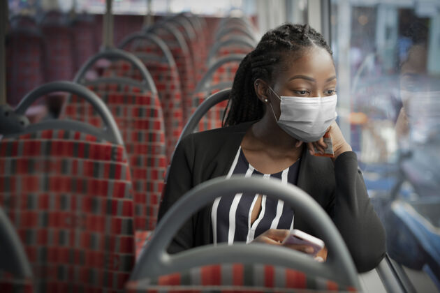 漂亮在新常态下乘坐公共交通工具时戴口罩的非裔美国妇女面具冠状病毒防护