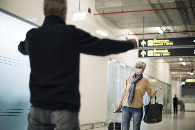 冠状病毒科维德-19被封锁后 一名男性大四在机场接他的妻子可打印围巾包