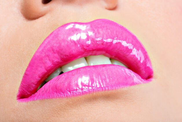 明亮用粉红唇膏贴近美丽的女性嘴唇魅力时尚亮泽妆容嘴唇唇彩光泽