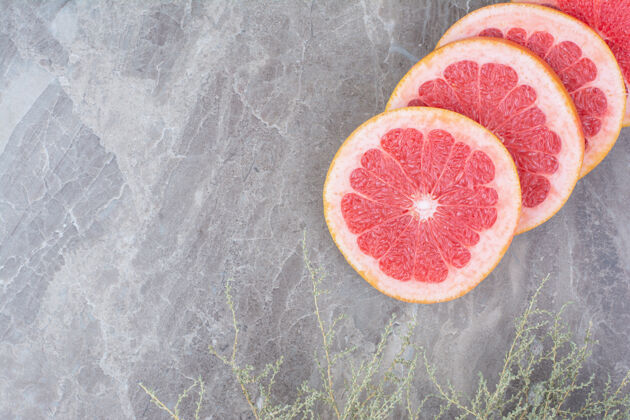 健康柚子片放在石头上 背景是植物柑橘美味水果