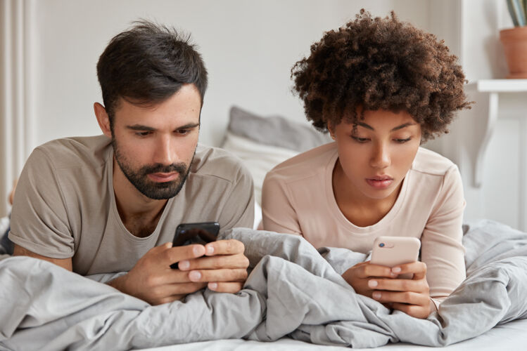 短信沉迷于网络中的多民族男女搜索信息 使用现代手机 观看视频或阅读博客 在床上休息 使用无线互联网现代技术和沉迷剃胡子小工具智能手机