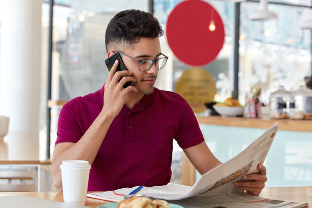男人年轻的男记者在新闻界做研究 看报纸 拿手机 打电话 喝外卖咖啡 坐在咖啡馆里人 休闲 大众传媒 科技眼镜最新文章