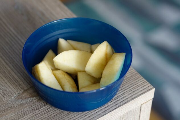 水果桌上蓝碗里的苹果片苹果美食多汁