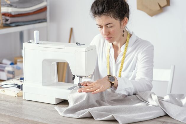 卧式女裁缝用缝纫机工作的正面图服装女工裁缝
