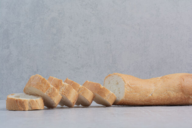 新鲜大理石背景上的新鲜白面包片烘焙糕点面包