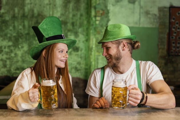 男士笑脸情侣在酒吧庆祝圣帕特里克节爱尔兰场合三叶草