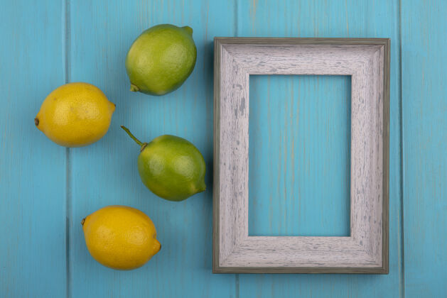复制顶视图复制空间灰色框架与柠檬和青绿色背景上的酸橙绿松石色墙顶部