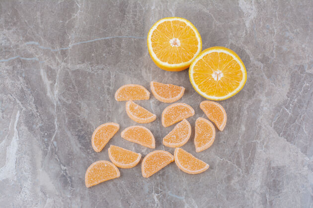 甜味新鲜的橘子片和甜甜的果酱放在大理石背景上柑橘美味食物