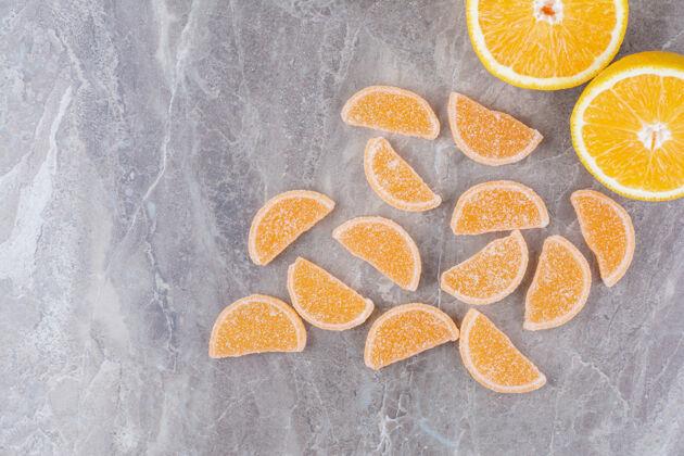 水果新鲜的橘子片和甜甜的果酱放在大理石背景上糖果食物美味