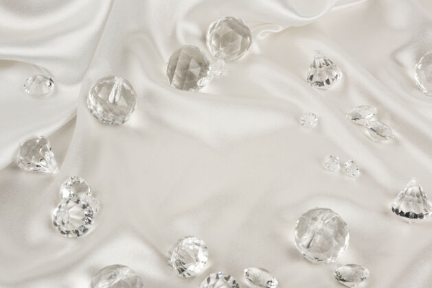 岩石白色织物上装饰性的透明钻石珠宝水晶闪亮