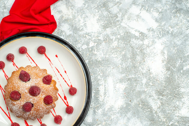 醋栗顶视图：白色椭圆形盘子上的浆果蛋糕 灰色表面上的红色披肩 带有复制空间美味顶部浆果