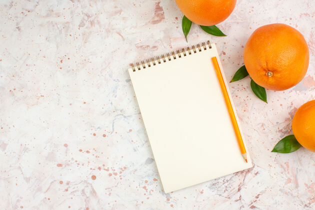 笔记顶视图新鲜的橙色橙色铅笔在明亮的独立表面上的记事本与自由空间鲜橙色视图明亮