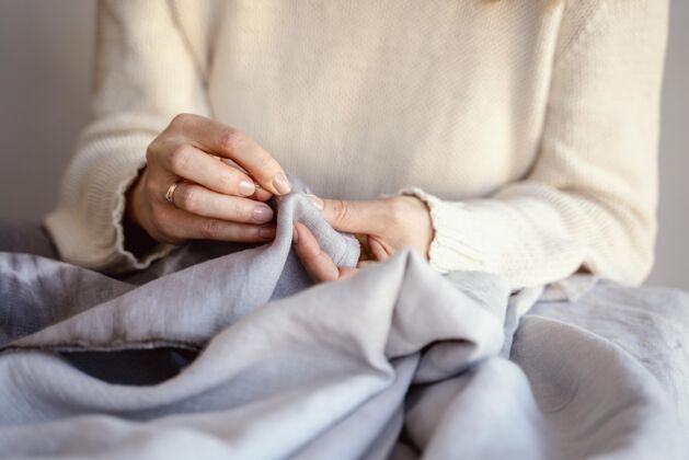 细节裁缝女人用针和线来缝纫面料工厂爱好